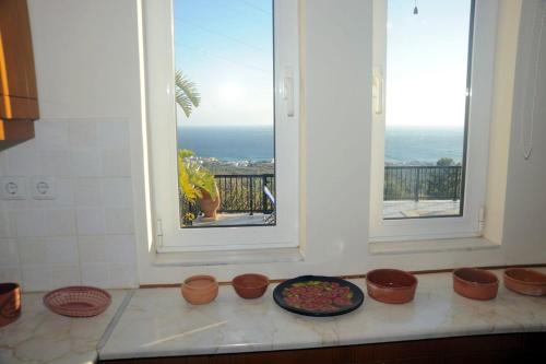 a kitchen with a window and bowls of food on a counter at Villa Panorama in Makry Gialos