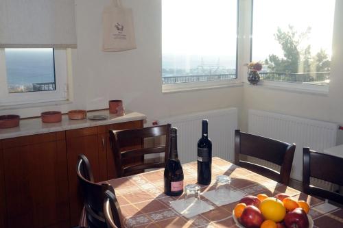 a table with two bottles of wine and a bowl of fruit at Villa Panorama in Makry Gialos