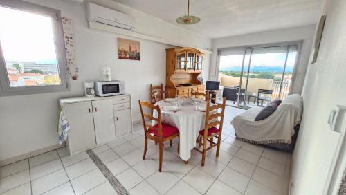 une cuisine et une salle à manger avec une table et des chaises dans l'établissement Bonna Blanca Appartement à 50 m de la plage , secteur marché - Clim, à Saint Cyprien Plage