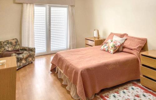 a bedroom with a bed and a chair and a window at Spacious House with Sea View in Angra do Heroísmo in Angra do Heroísmo