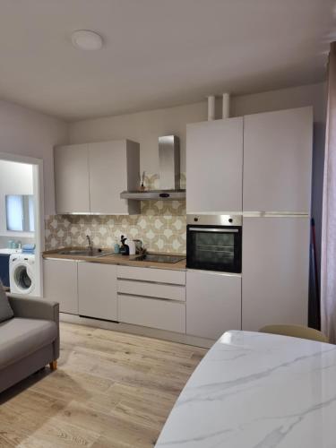 a kitchen with white cabinets and a stove top oven at Casa Candio in Pavia