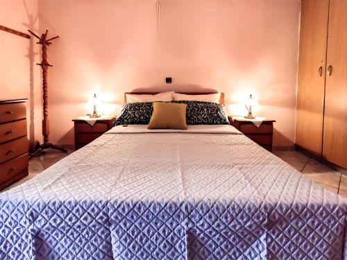 Un dormitorio con una cama grande con dos lámparas. en Kalimera Apartments, en Kokkari