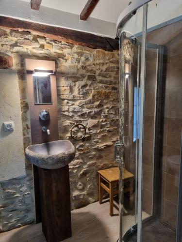 un bagno in pietra con lavandino e doccia di Hotel Rural La Casa Encanto a Espinosa de los Monteros