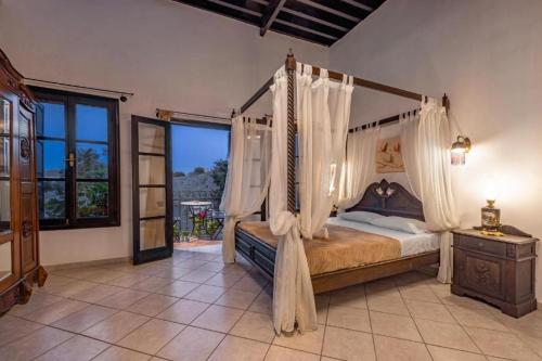a bedroom with a canopy bed and a window at Saint Michel Hotel in Rhodes Town