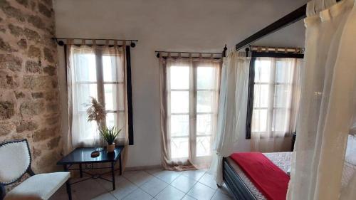 a bedroom with a bed and two large windows at Saint Michel Hotel in Rhodes Town