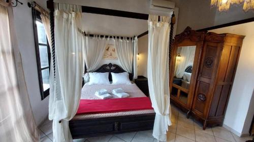 a bedroom with a canopy bed with shoes on it at Saint Michel Hotel in Rhodes Town
