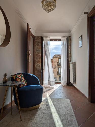 a living room with a blue chair and a table at Passo del Mattino in Locati