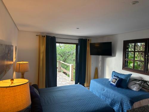 a hotel room with two beds and a window at Suites com vista para o mar in Ilhabela
