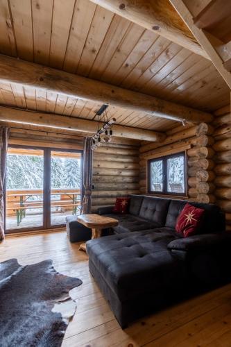 a living room with a black couch and a table at Casa Montana in Kopaonik