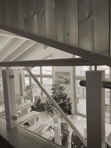 a staircase with a christmas tree in a room at Victoria's Home - luxurious penthouse in Saas-Fee
