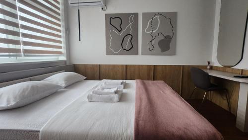 a bedroom with a bed with two towels on it at Apartmani Dobrinja - Free parking- Rent a car in Sarajevo