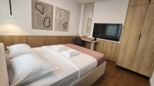 a bedroom with a bed and a flat screen tv at Apartmani Dobrinja - Free parking- Rent a car in Sarajevo