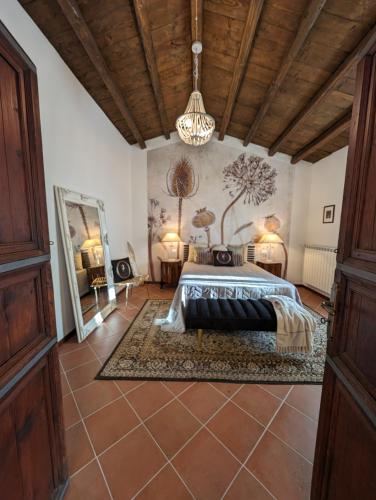 a bedroom with a bed and a chandelier at Passo del Mattino in Locati