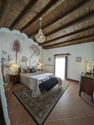 a bedroom with a large bed and a chandelier at Passo del Mattino in Locati