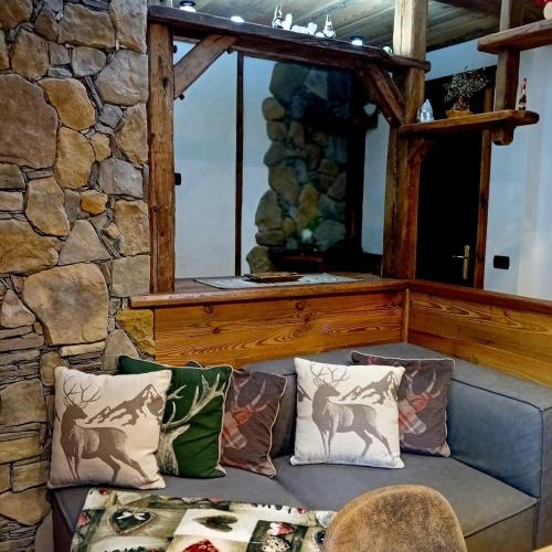 a couch in a room with a stone wall at Le petit bijou in Aosta