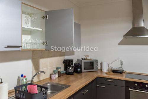 a kitchen with a sink and a microwave at Lux apartment - one bedroom , living room , kitchen , bathroom - for 1 to 7 people, also for parties & gatherings up to 25 people, only 15 minutes from Thessaloniki city center and 8' minutes from Thessaloniki airport in Néon Rýsion