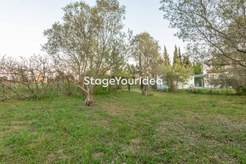 a sign in a field with trees and a house at Lux apartment - one bedroom , living room , kitchen , bathroom - for 1 to 7 people, also for parties & gatherings up to 25 people, only 15 minutes from Thessaloniki city center and 8' minutes from Thessaloniki airport in Néon Rýsion