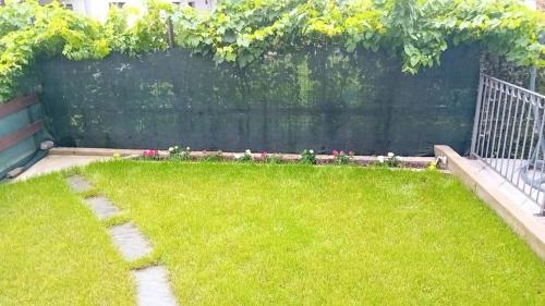 a backyard with a fence and a grass yard at Le petit bijou in Aosta