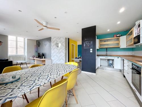 une cuisine et une salle à manger avec une table et des chaises jaunes dans l'établissement La roue libre 3 chambres - 1er étage au centre ville de L'Arbresle, à Éveux