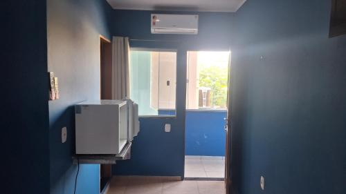 a room with a blue wall and a window at Pousada Malibu itaoca in Itapemirim