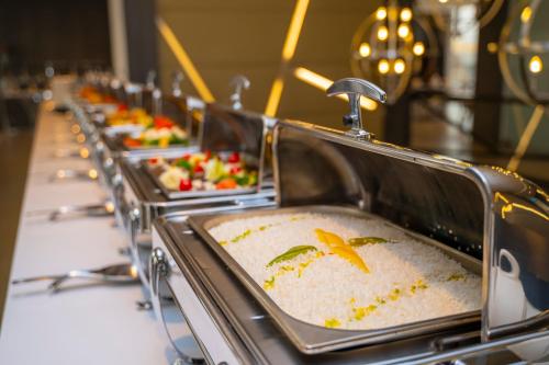 a row of trays of food on a buffet line at Executives Hotel - KAFD in Riyadh