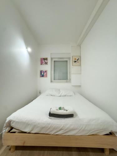 une chambre avec un grand lit blanc dans une pièce dans l'établissement Héra, à Caen