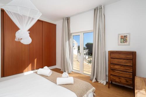 AlagoasにあるCama da Vaca 3のベッドと大きな窓のある寝室