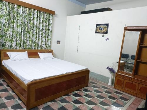 a bedroom with a bed and a dresser and a window at The Ganga Home Stay in Prayagraj