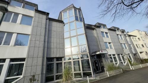 a large building with glass windows on a street at Astoria City Resort in Essen