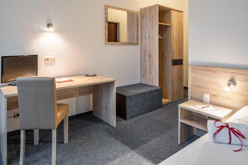 a room with a bed and a desk with a computer at Astoria City Resort in Essen