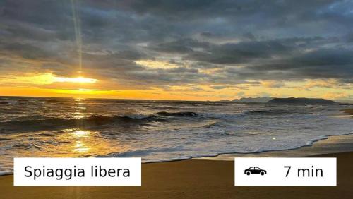 a sunset over the ocean with a car on the beach at Perla Azzurra - Forte dei Marmi - Cinque Terre in Montignoso