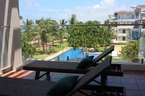 a balcony with a view of a pool and palm trees at Sandy Shores in Nilaveli