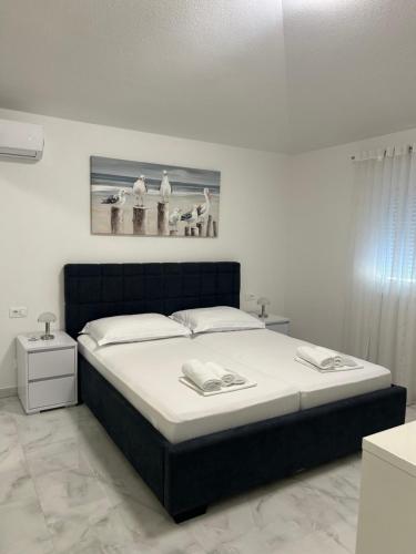a bedroom with a bed and a picture on the wall at MAK apartment in Kaštela