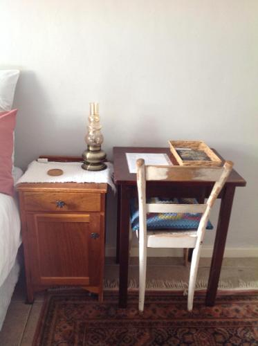 a wooden desk with a chair next to a bed at The Pink Door in Caledon