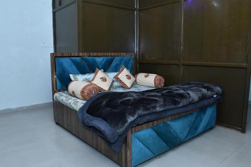 a wooden bed with pillows on it in a room at Independent House in Jaipur in Jaipur