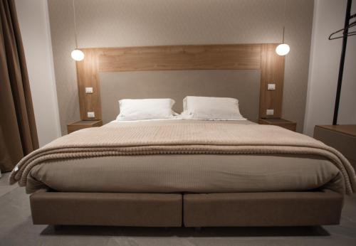 a bedroom with a large bed with two pillows at Alexander House Hotel in San Ferdinando
