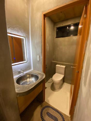 a bathroom with a sink and a toilet at Ohayo Siargao in General Luna