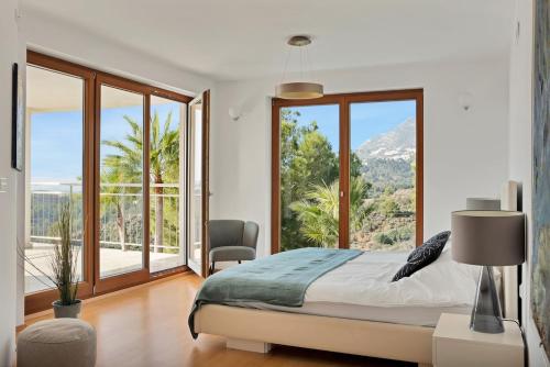 a bedroom with a bed and a large window at Villa -Heated pool -Amazing view -Ideal for groups in Mijas