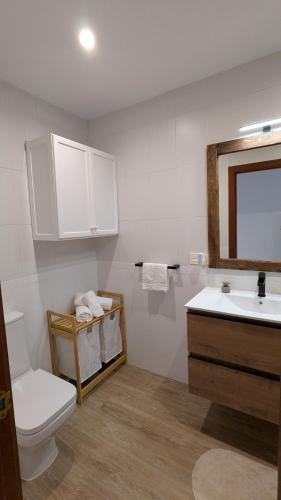 a bathroom with a toilet and a sink and a mirror at Atico Arcos Terraza Relax in Arcos de la Frontera