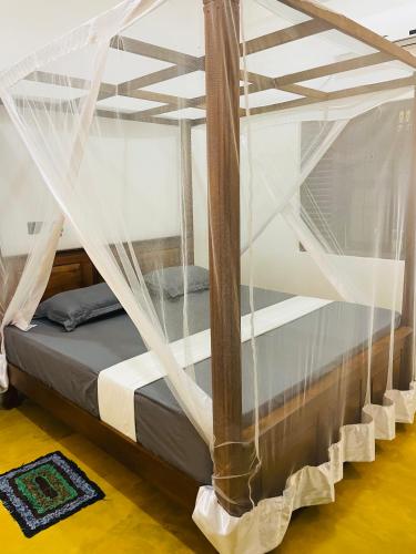 a bed with mosquito netting over it in a room at 07th Heaven Villa in Tangalle