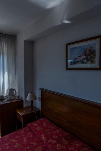 a hotel room with a bed and a picture on the wall at Hotel Isola Bella in Taormina