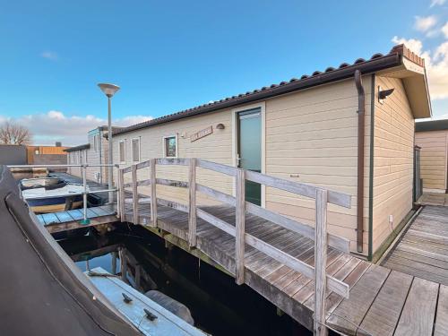 a house with a dock next to a building at VISSERSLUST Rooms, Apartments and Houseboats in Vinkeveen