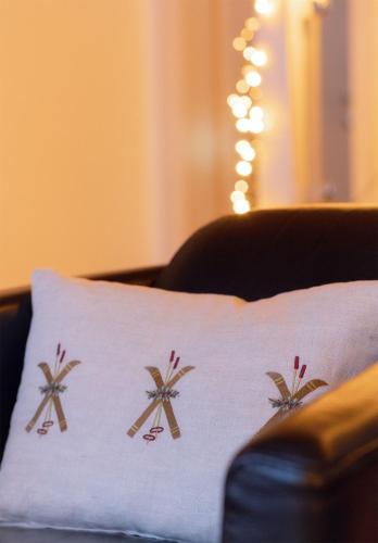 a white pillow with palm trees on it on a couch at Victoria's Home - luxurious penthouse in Saas-Fee