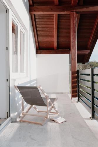 a steel chair on a porch with a wooden ceiling at Elbe Holiday in Donja Stubica