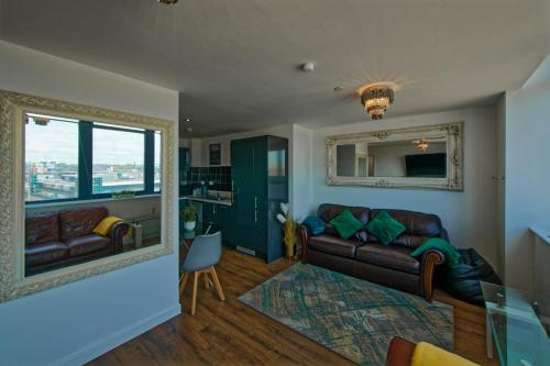 Una sala de estar con un sofá y un espejo. en Sidemersey Livings - 2 Bedroom Central Apartment with views, en Liverpool