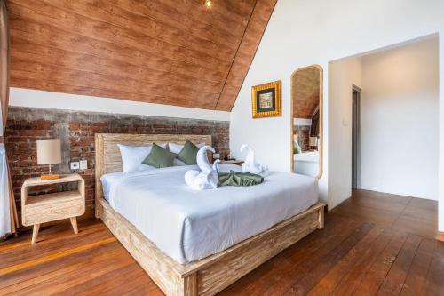 a bedroom with a large bed with white sheets at green slope villa glamping in Gitgit
