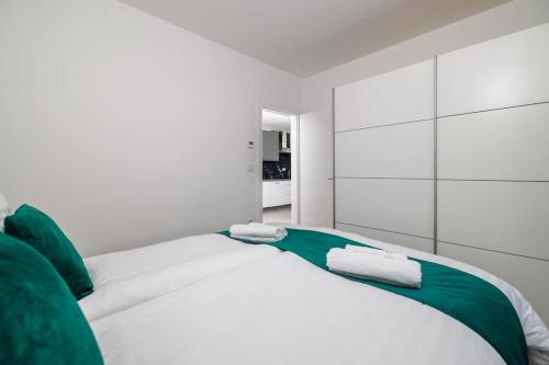 1 dormitorio blanco con 1 cama grande con almohadas verdes en Panorama Residence, en Crikvenica