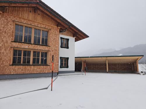 a building with a snow covered parking lot in front of it at Ferienhaus Weitblick, Apartment Ritzinger GmbH in Stixenlehen