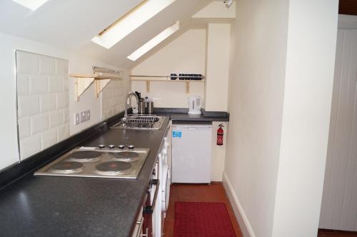 a kitchen with a sink and a stove top oven at 2 Buckatree Cottage in Wellington