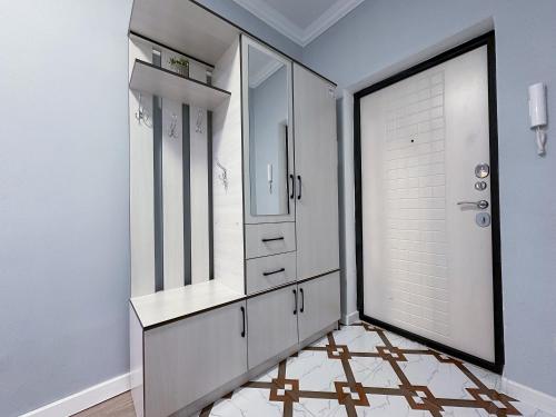 ein Badezimmer mit einem großen Spiegel und ein Ankleidezimmer in der Unterkunft Просторная квартира для большой компании in Almaty